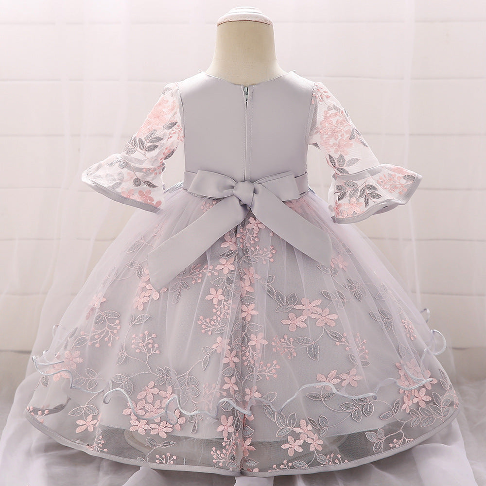 Baby girl wearing an elegant embroidered pattern tutu formal dress with medium sleeves in pink color.