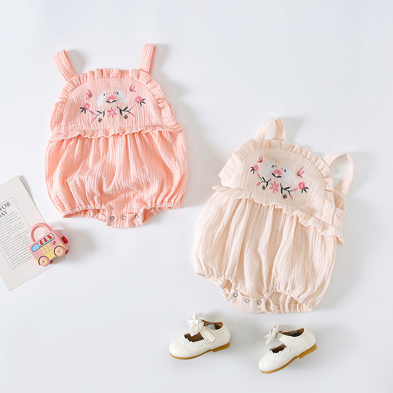 Baby girl wearing a floral embroidered sleeveless onesie in pink, showcasing lace design and solid color, perfect for summer.