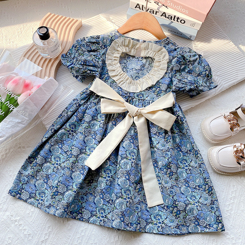 A beautiful baby girl dress featuring floral embroidery and lace patchwork, designed with puff sleeves and a backless silhouette in blue.