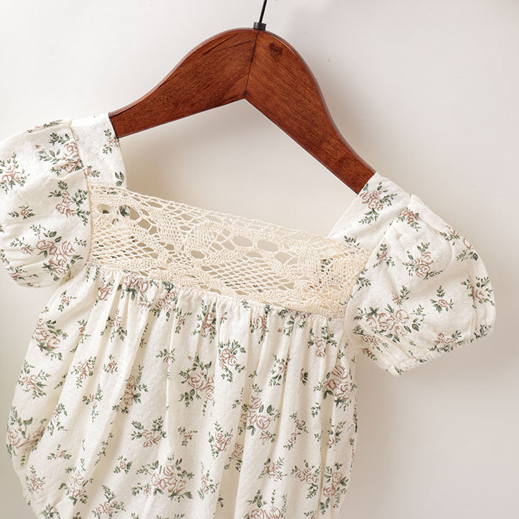 Baby girl outfit featuring floral pattern, lace patchwork, backless design, and bubble sleeves in white and beige colors.