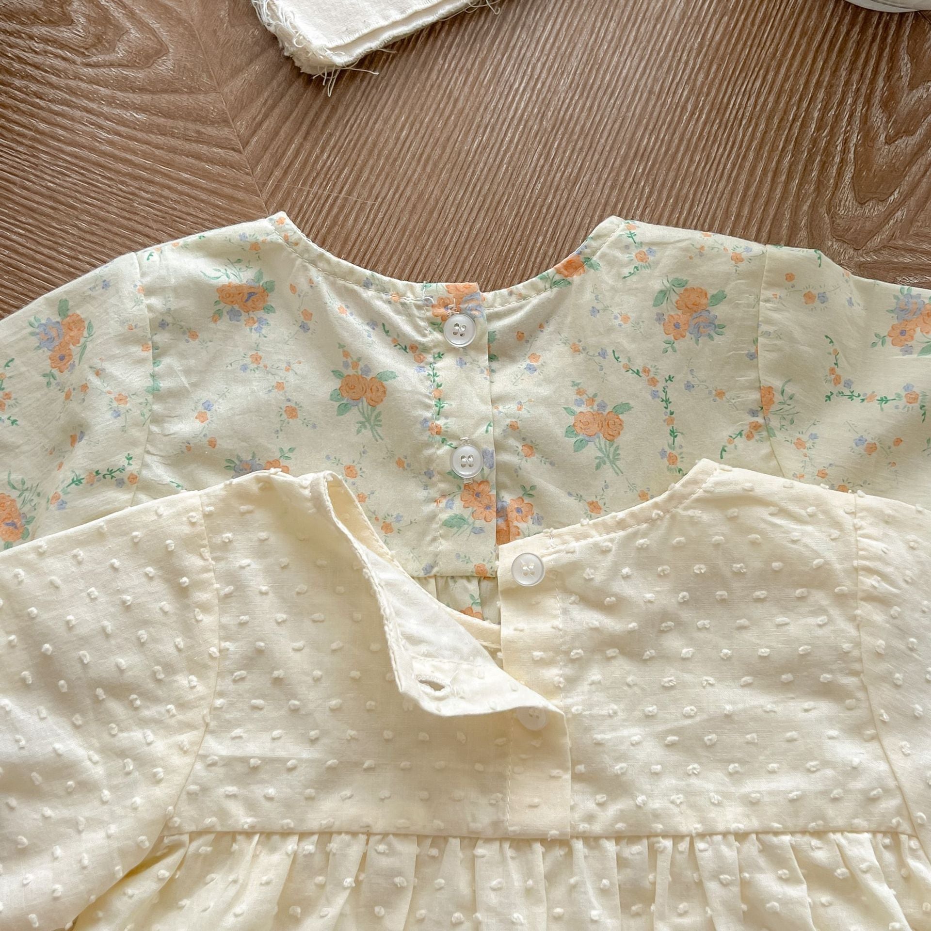 Baby girl wearing a long sleeve jumpsuit with floral pattern, showcasing soft cotton fabric and vibrant colors.