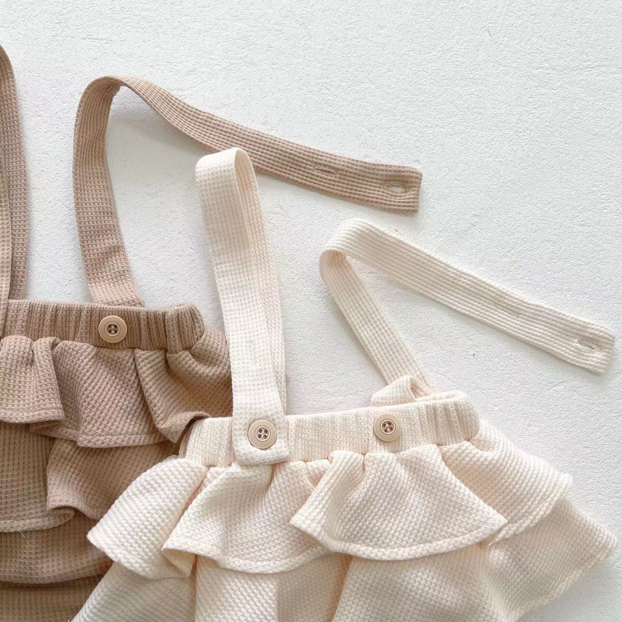 Baby girl wearing a floral pattern ruffle neck shirt combo made of soft corduroy fabric, showcasing apricot and brown colors.