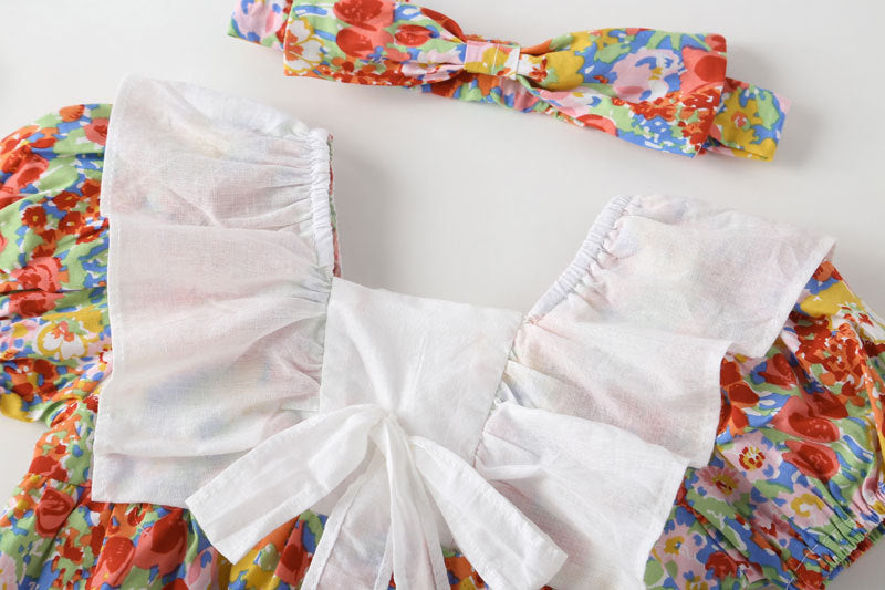 Baby girl onesie featuring a floral pattern, white bow patchwork, and square neckline, perfect for summer wear.