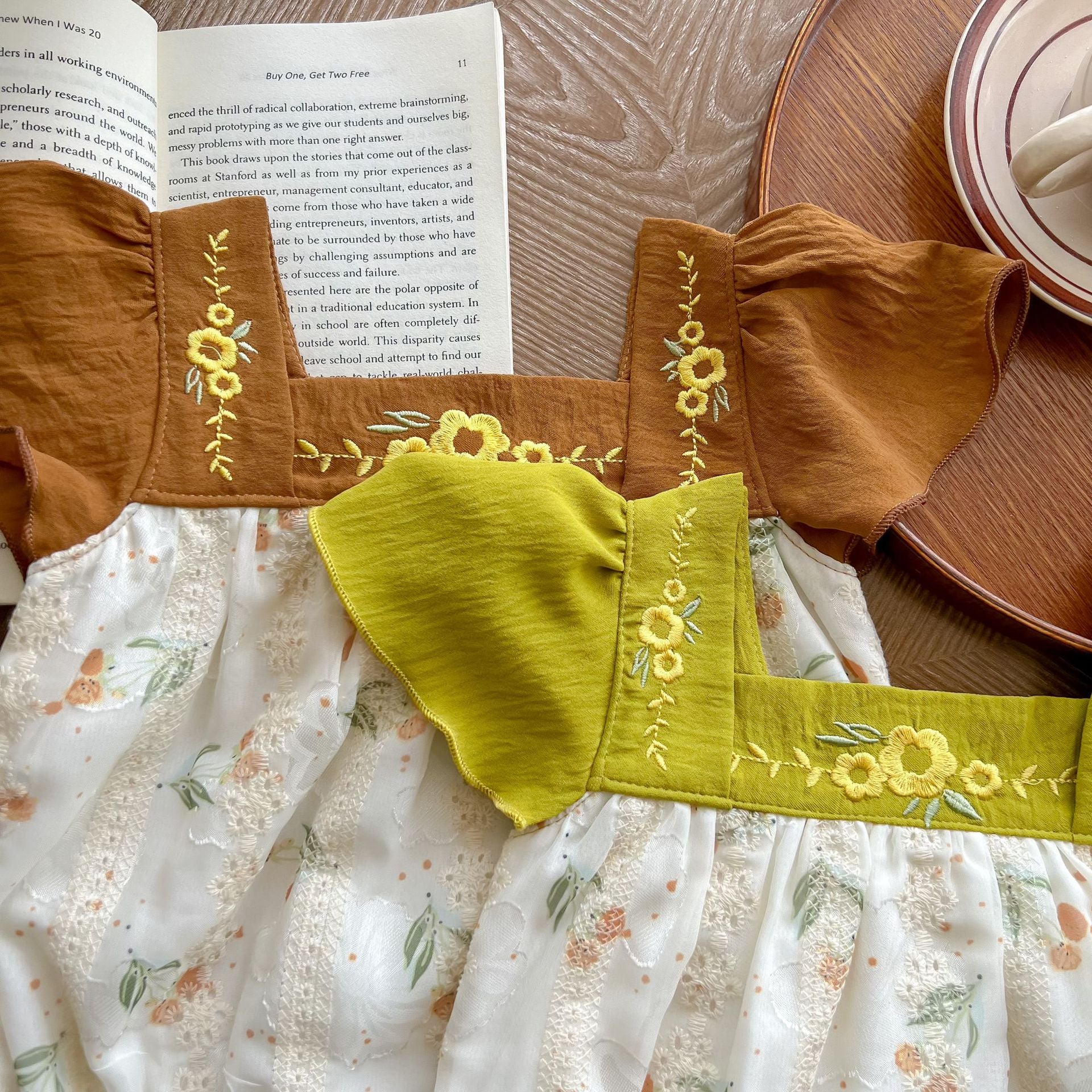 Baby girl floral print onesie with embroidered design and ruffle sleeves in green and brown colors.