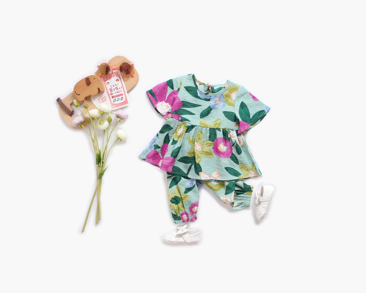 Adorable baby girl wearing a floral print O-neck T-shirt and matching trousers set, showcasing vibrant colors and a stylish design.