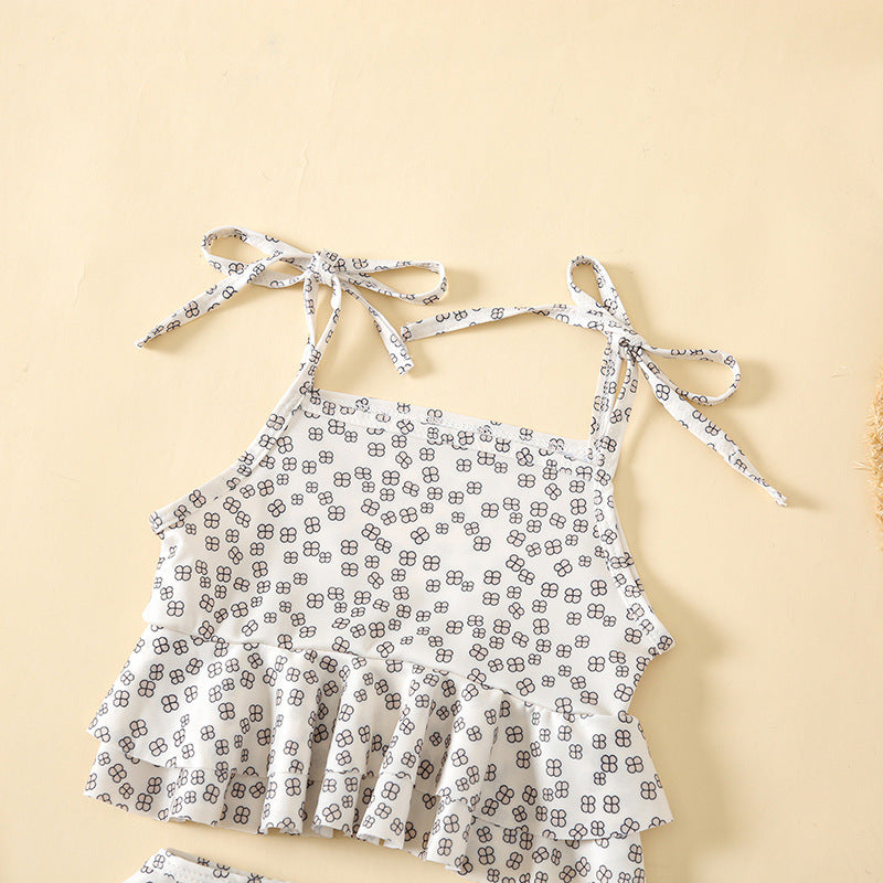 Baby girl wearing a floral print sling top and shorts combo, featuring a playful belt design, perfect for summer outings.