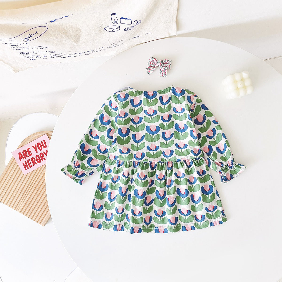 A beautiful baby girl dress featuring a floral print pattern with a doll neck and A-line design, available in red and green colors.