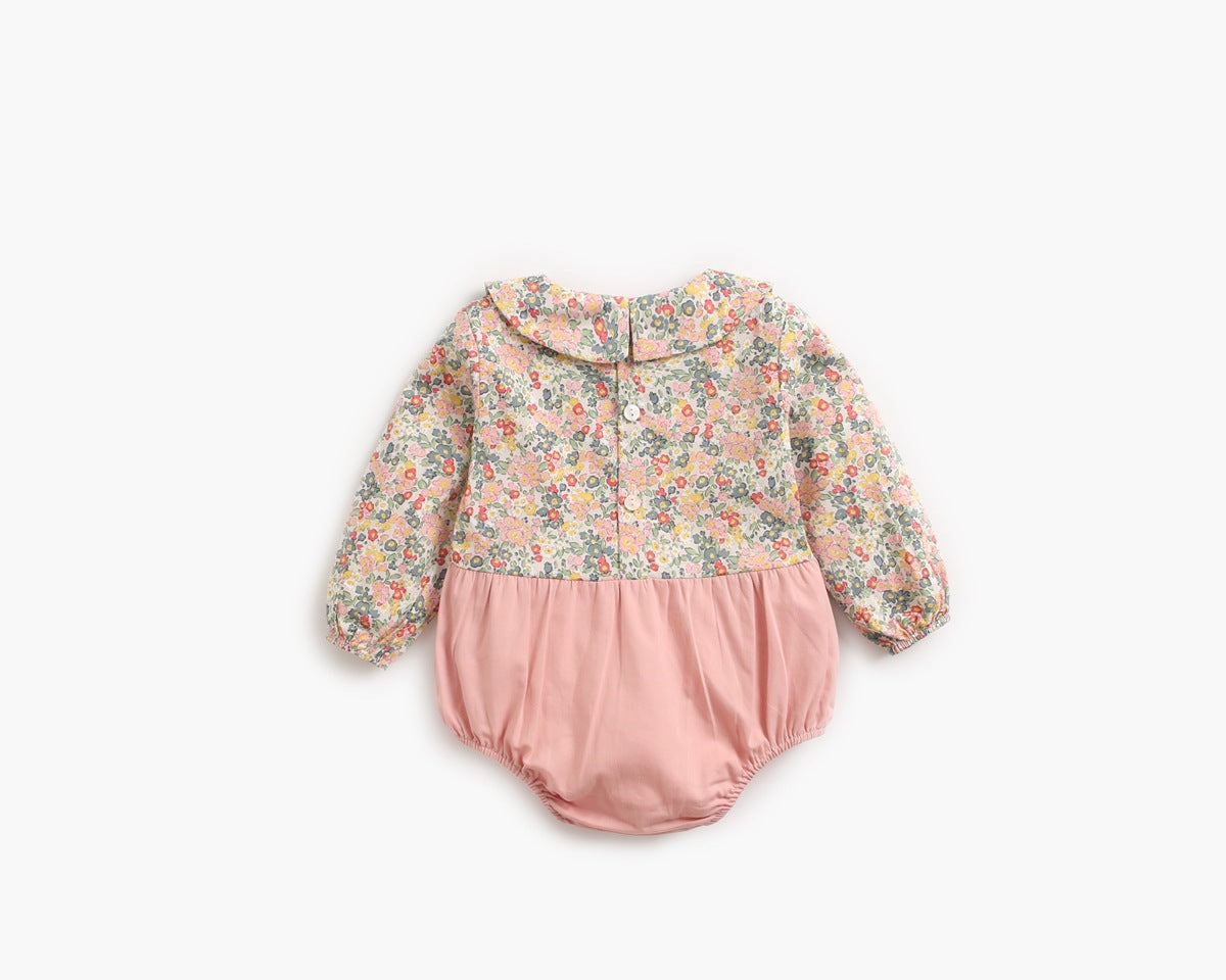 A vibrant pink long-sleeved onesie for baby girls featuring a cheerful floral print pattern, made from soft cotton material.