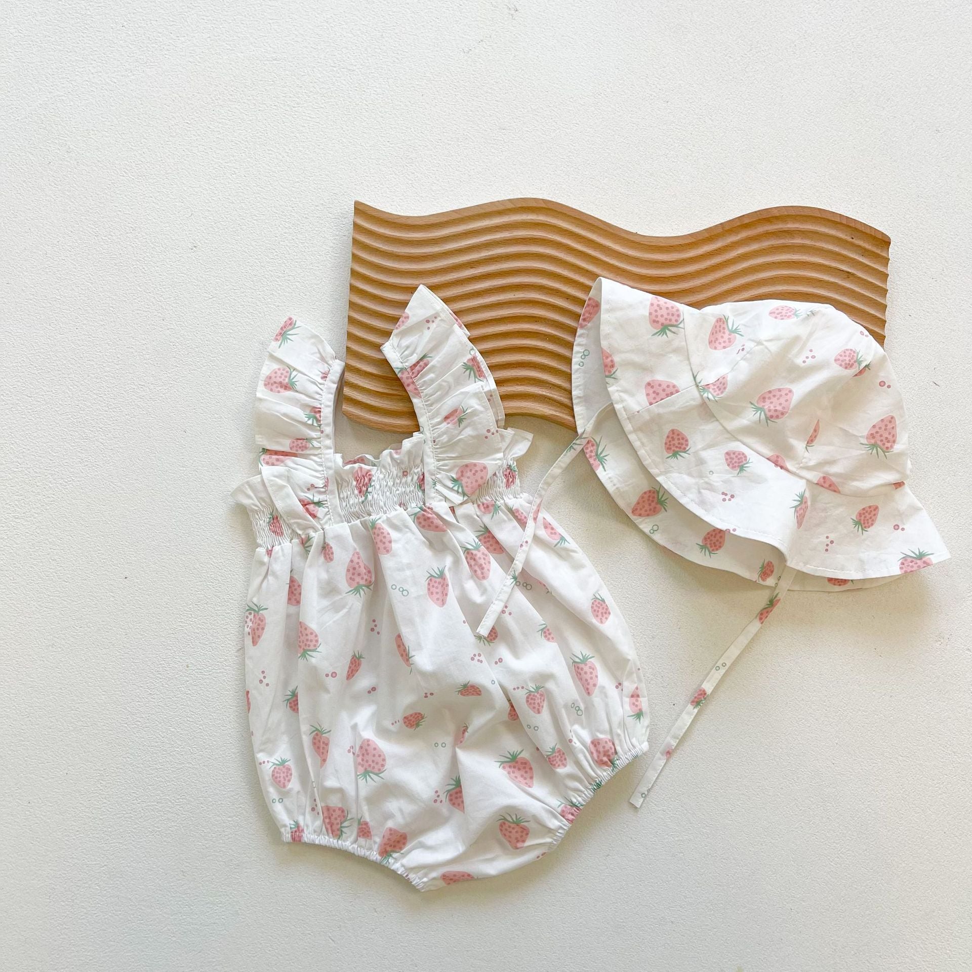 Baby girl wearing a floral print ruffle design sleeveless crotch onesie in pink, showcasing a cute and stylish summer outfit.