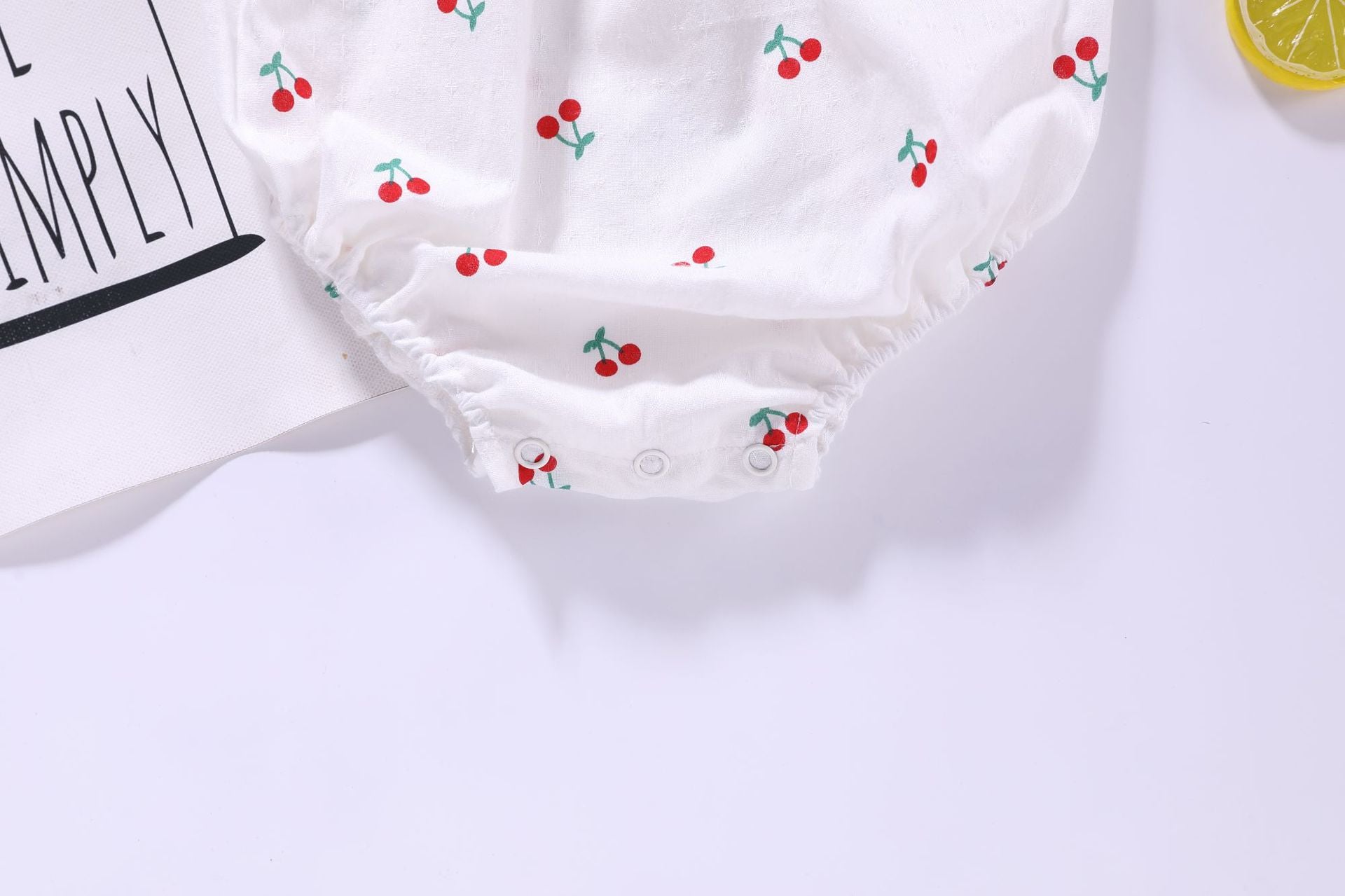 Baby girl wearing a floral print ruffle design sling onesie in vibrant colors, perfect for summer outings.