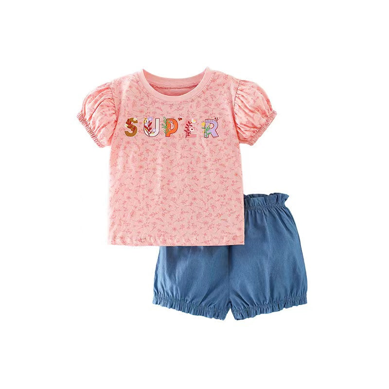 Baby girl wearing a floral and slogan print puff sleeve tee with denim shorts, showcasing a trendy summer outfit.