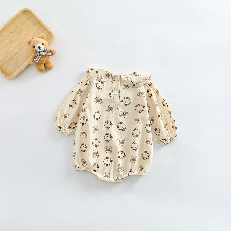 Baby girl bodysuit featuring a flower and bear print pattern with a doll neckline and ruffle details, made from soft cotton.