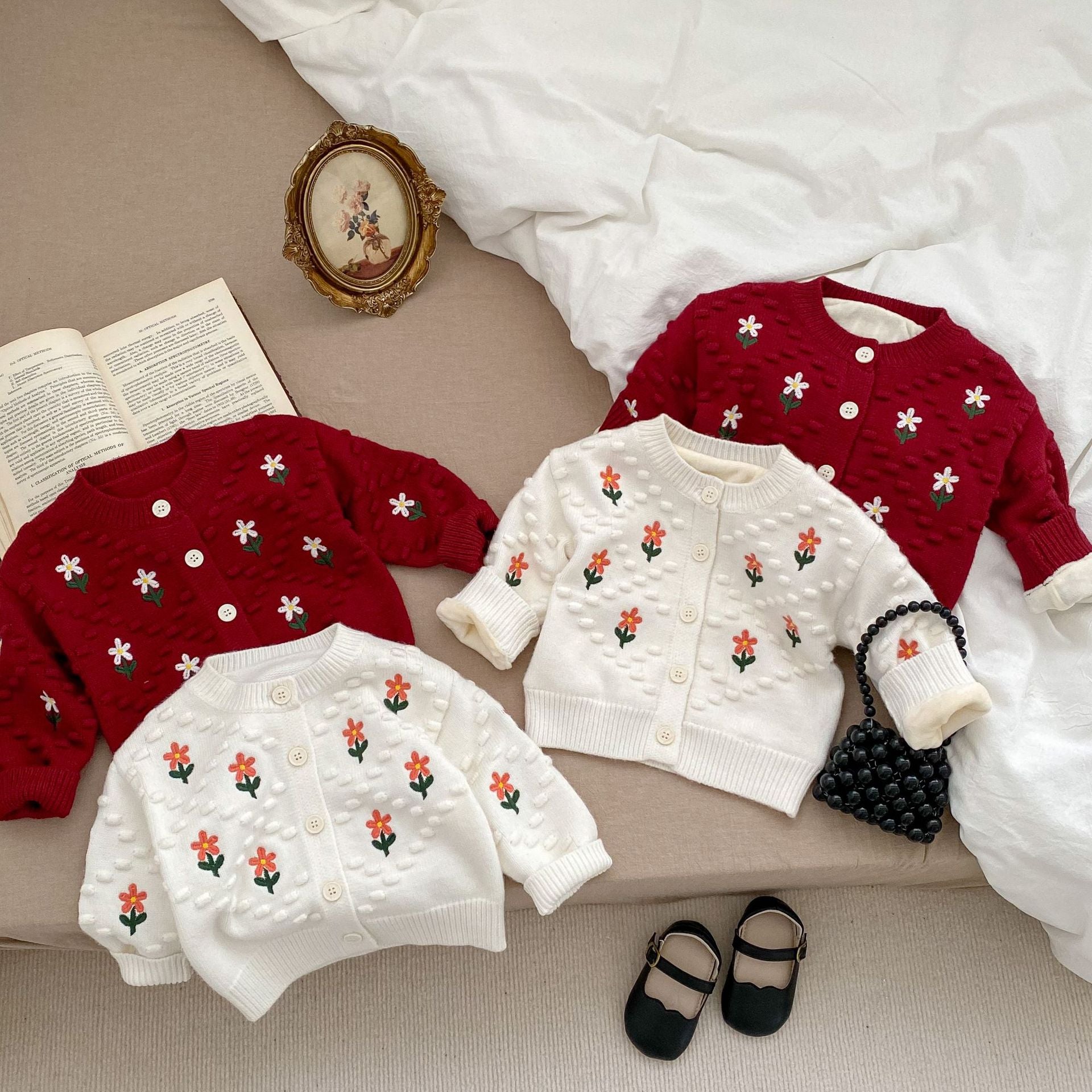 A cozy baby girl cardigan featuring flower embroidery, thickened knit design, available in white and red colors.