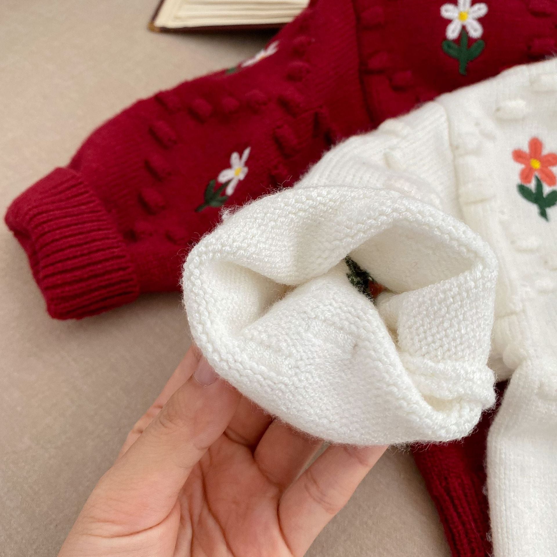 A cozy baby girl cardigan featuring flower embroidery, thickened knit design, available in white and red colors.