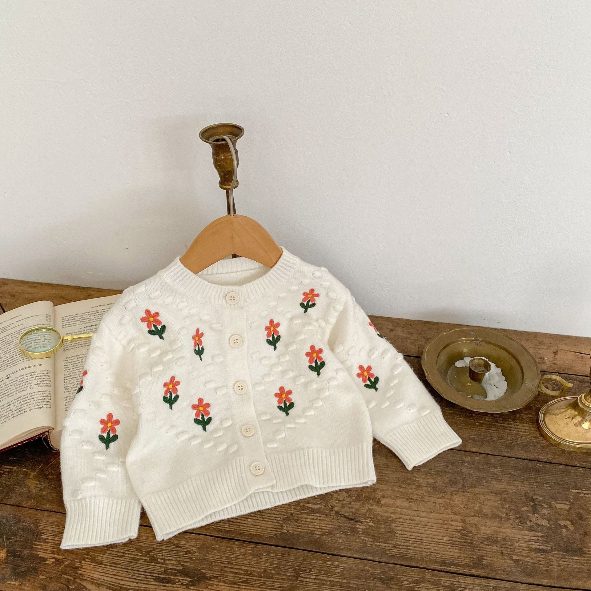 A cozy baby girl cardigan featuring flower embroidery, thickened knit design, available in white and red colors.