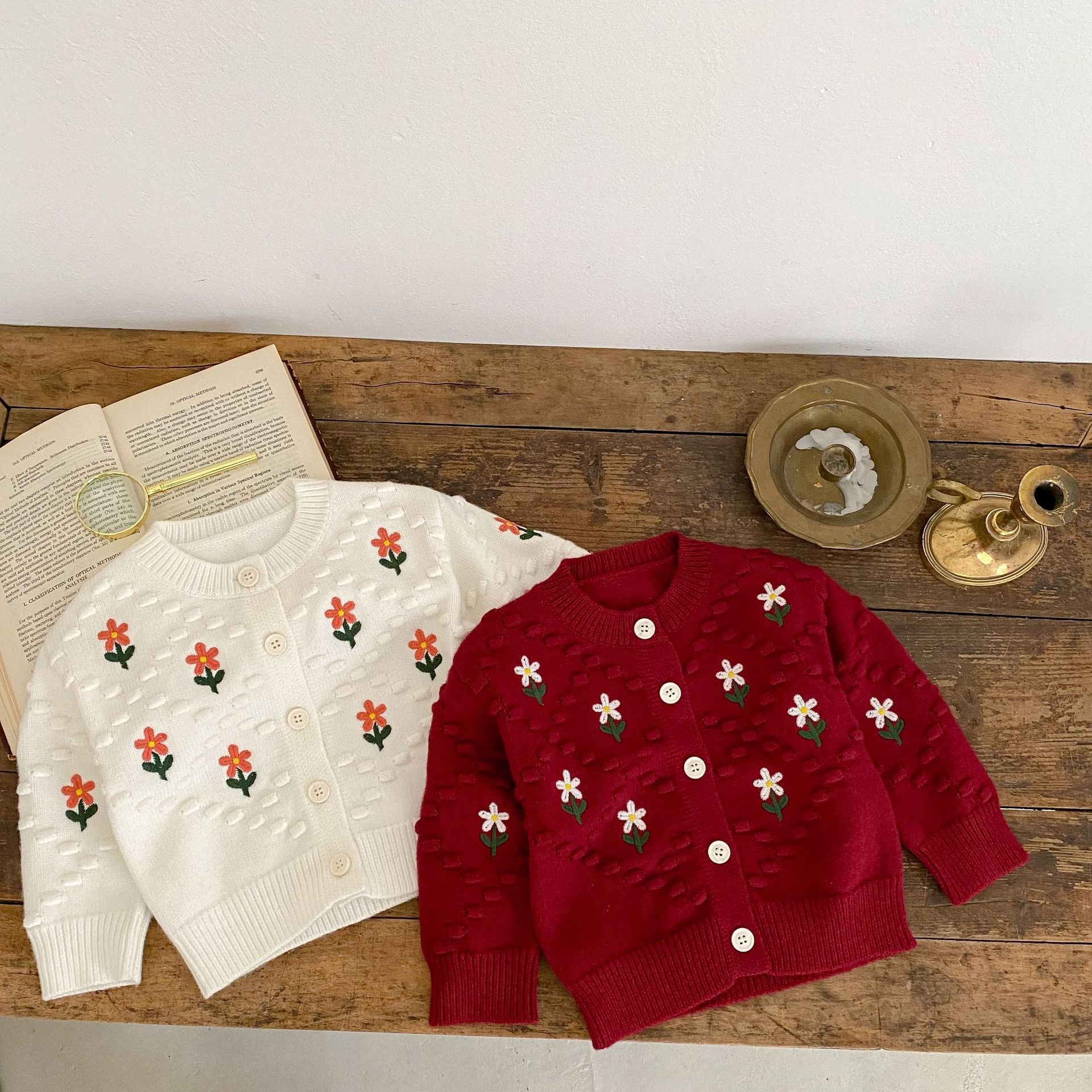 A cozy baby girl cardigan featuring flower embroidery, thickened knit design, available in white and red colors.