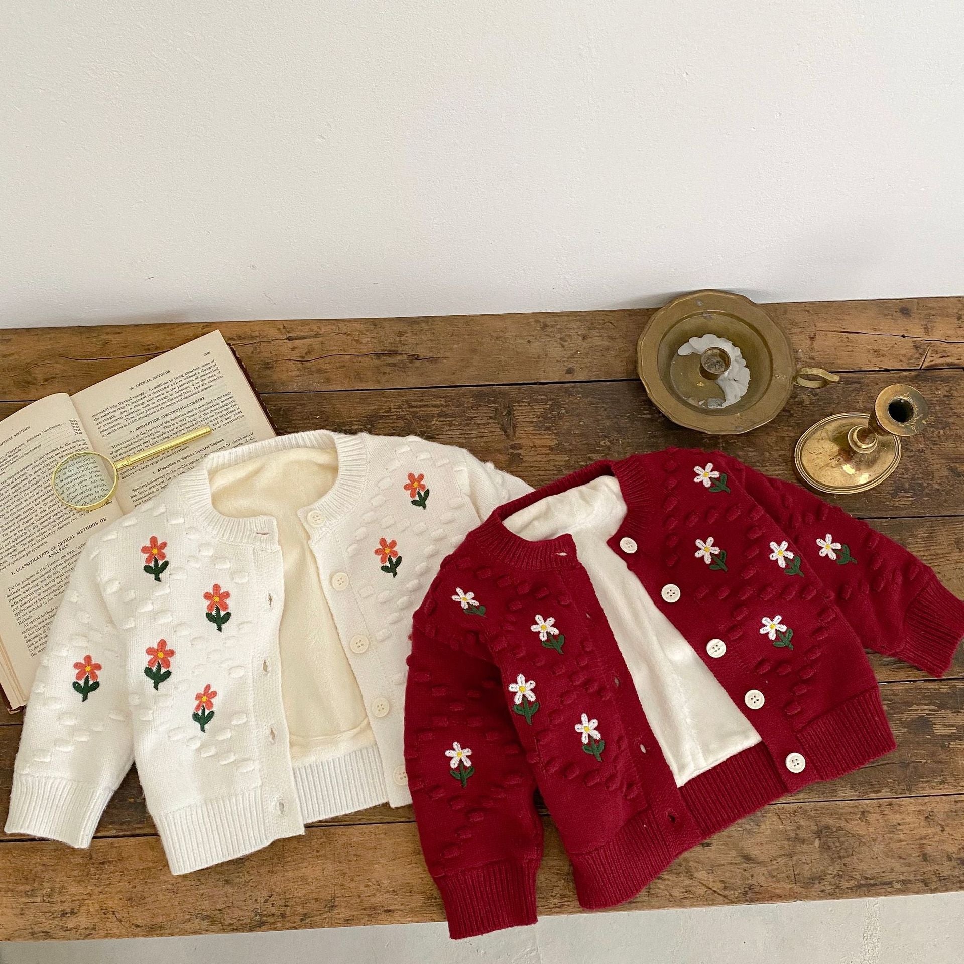 A cozy baby girl cardigan featuring flower embroidery, thickened knit design, available in white and red colors.