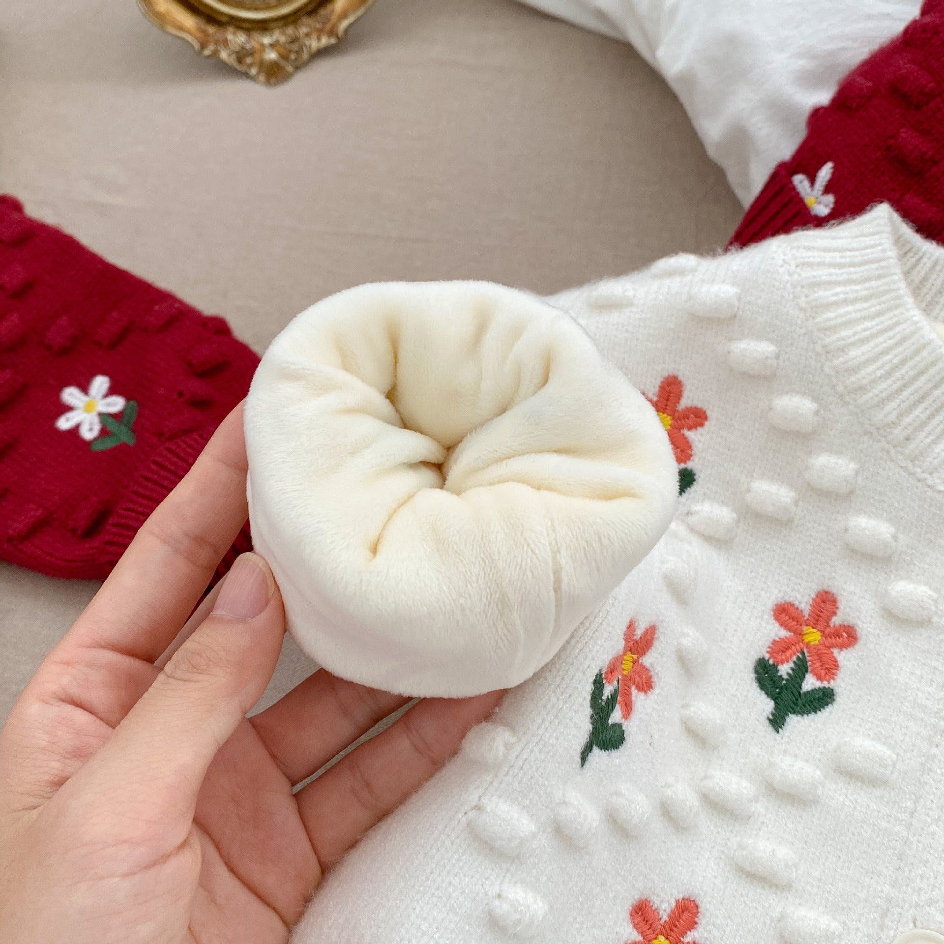 A cozy baby girl cardigan featuring flower embroidery, thickened knit design, available in white and red colors.