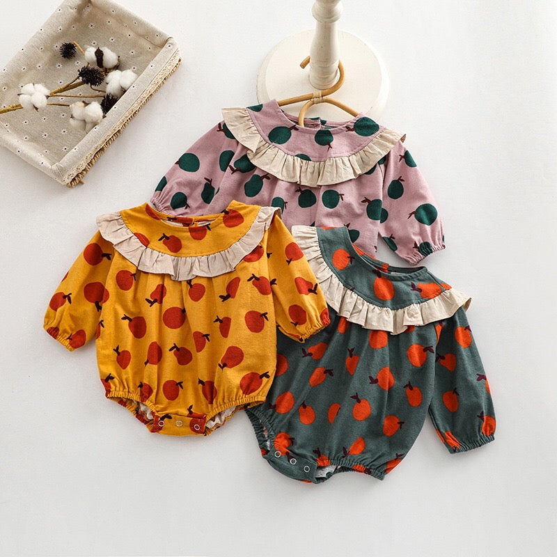 Baby girl long sleeve onesies featuring a vibrant fruit orange patchwork design in pink, green, and yellow colors.