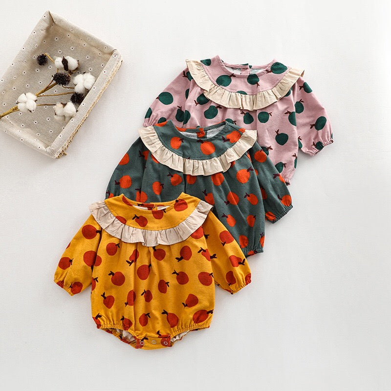 Baby girl long sleeve onesies featuring a vibrant fruit orange patchwork design in pink, green, and yellow colors.