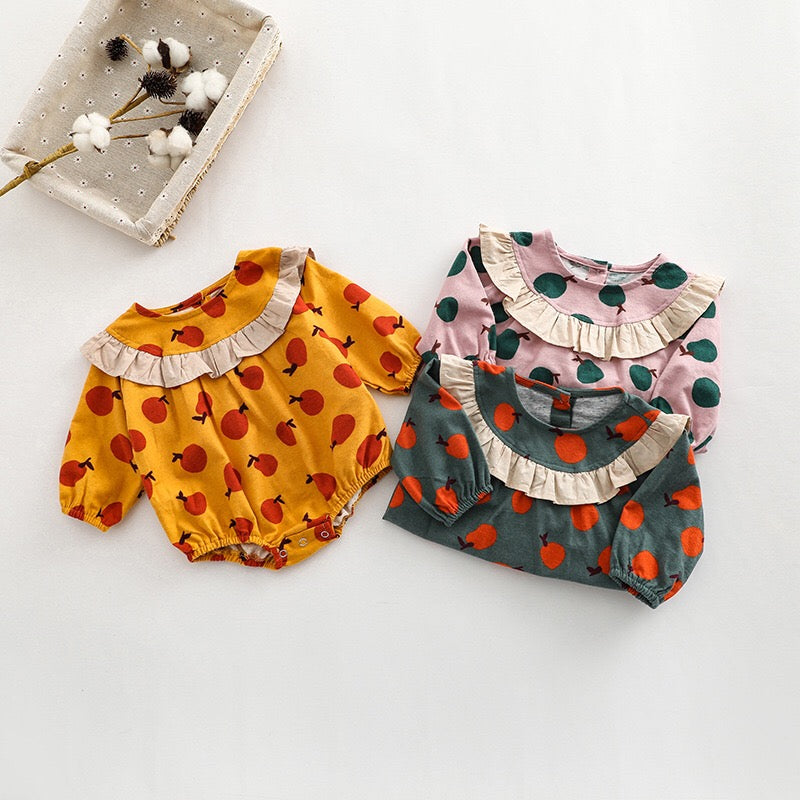 Baby girl long sleeve onesies featuring a vibrant fruit orange patchwork design in pink, green, and yellow colors.