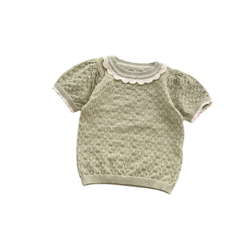 A cute baby girl wearing a hollow carved design ruffle knit tee in pink, showcasing its charming details and soft cotton material.