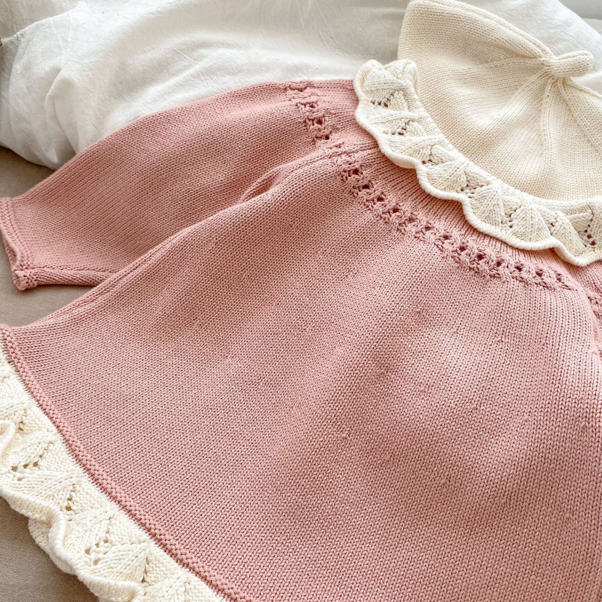 A baby girl wearing a pink embroidered long-sleeved cardigan, showcasing its soft cotton fabric and stylish design.