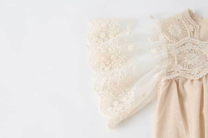 Baby girl lace-sleeved onesie in white and apricot colors, featuring delicate lace sleeves and collar, perfect for summer occasions.