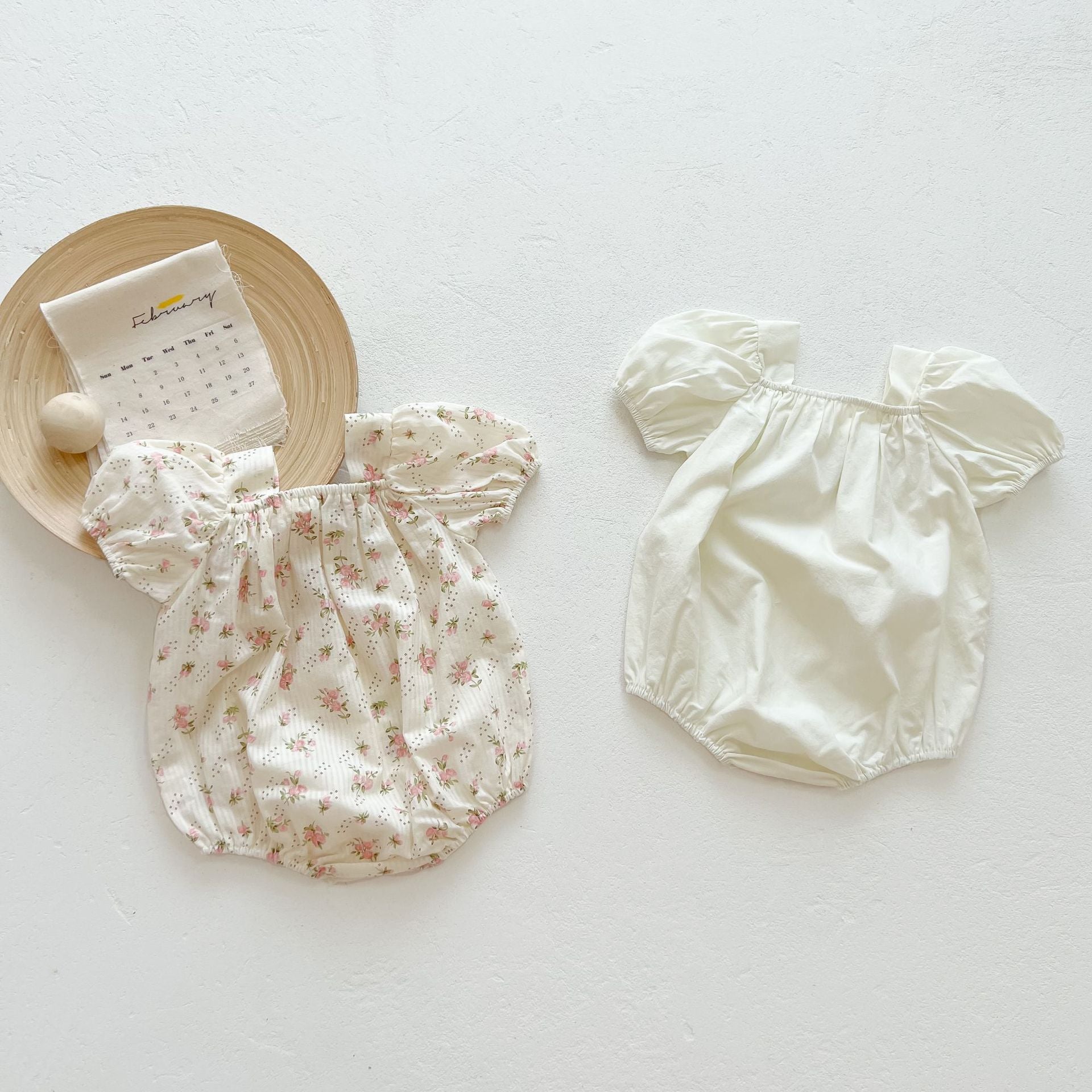 Baby girl onesie featuring a lovely bow-tie design, short sleeves, available in beige and apricot colors.