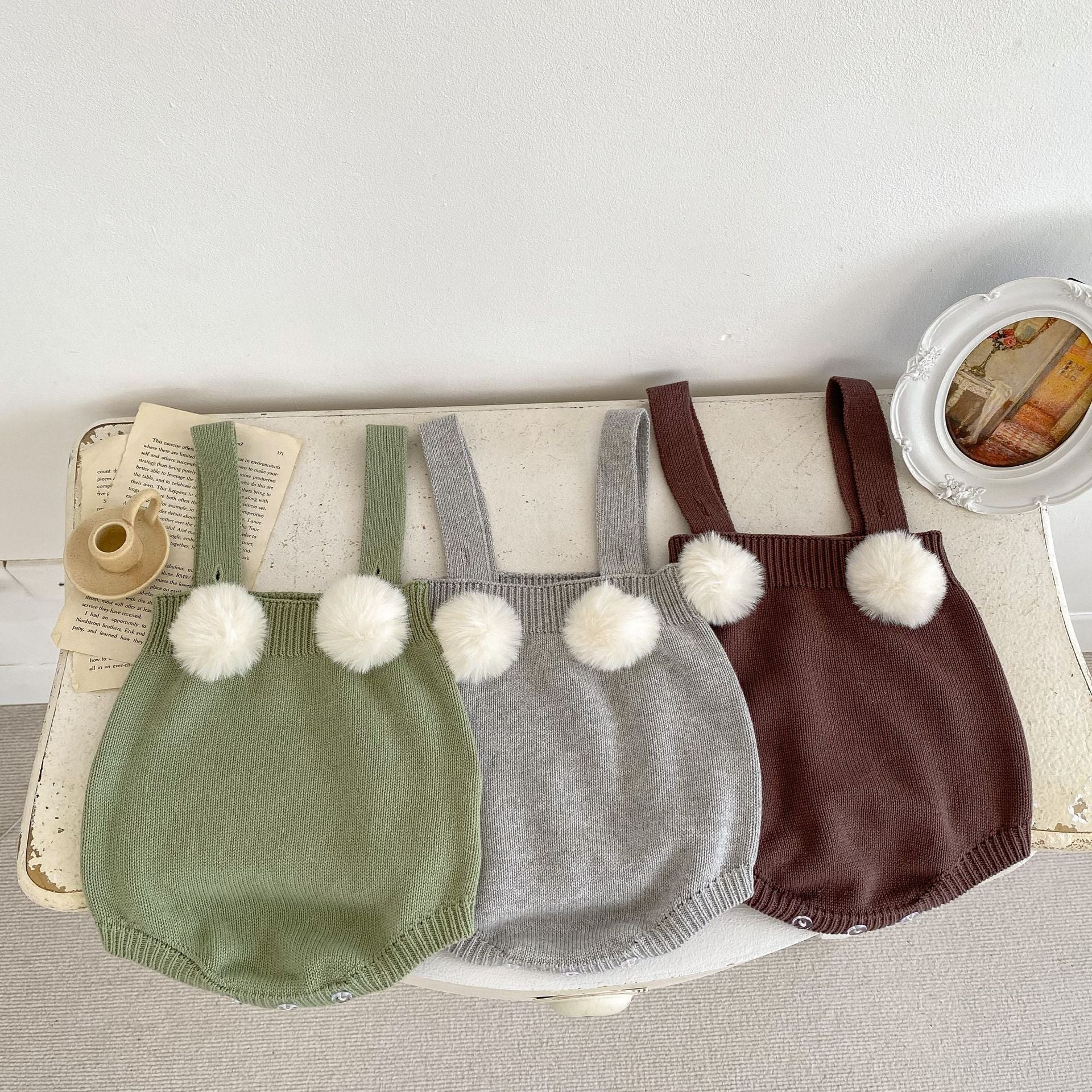 Baby girl wearing a plush ball camisole knitted vest in green, showcasing its soft cotton material and stylish design.