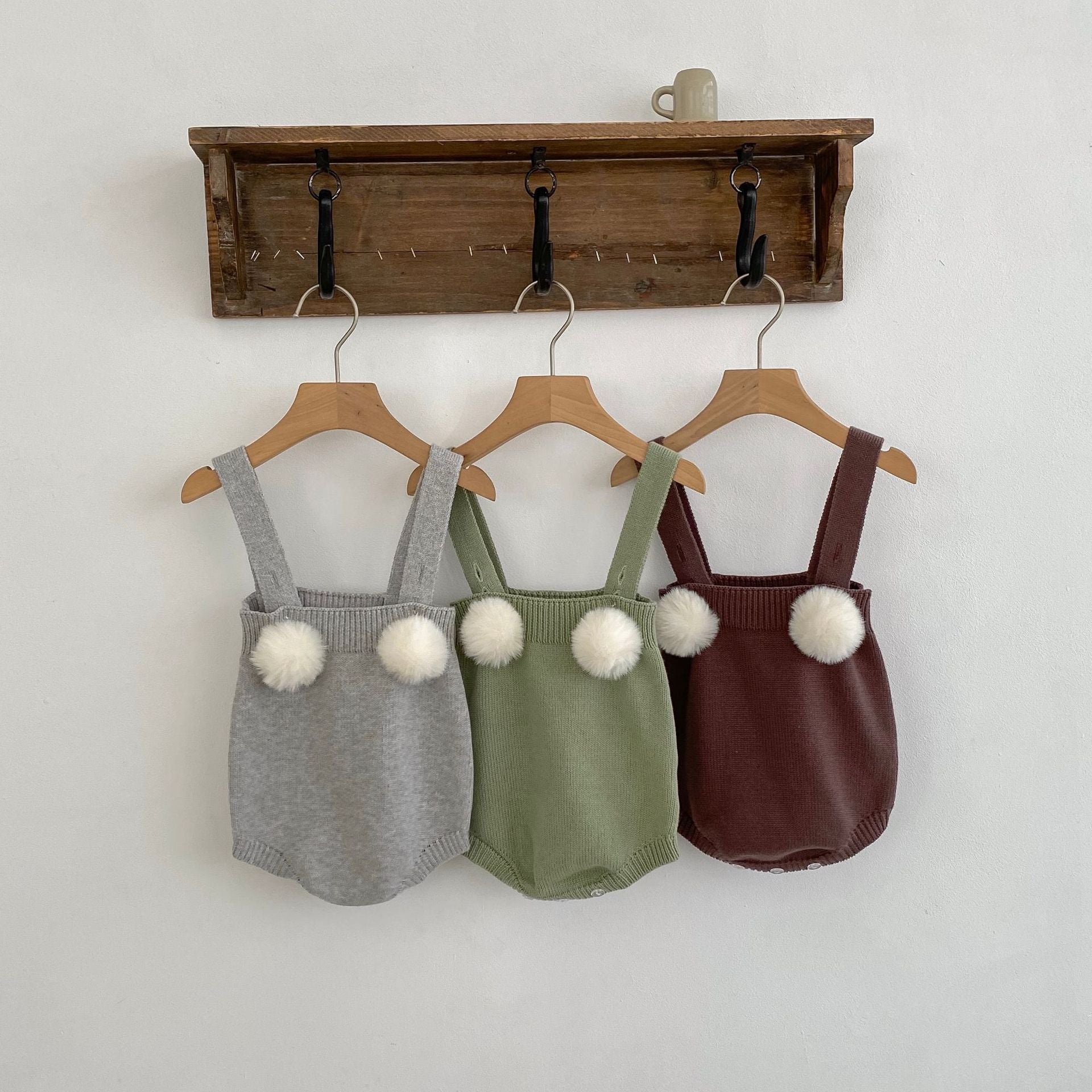 Baby girl wearing a plush ball camisole knitted vest in green, showcasing its soft cotton material and stylish design.