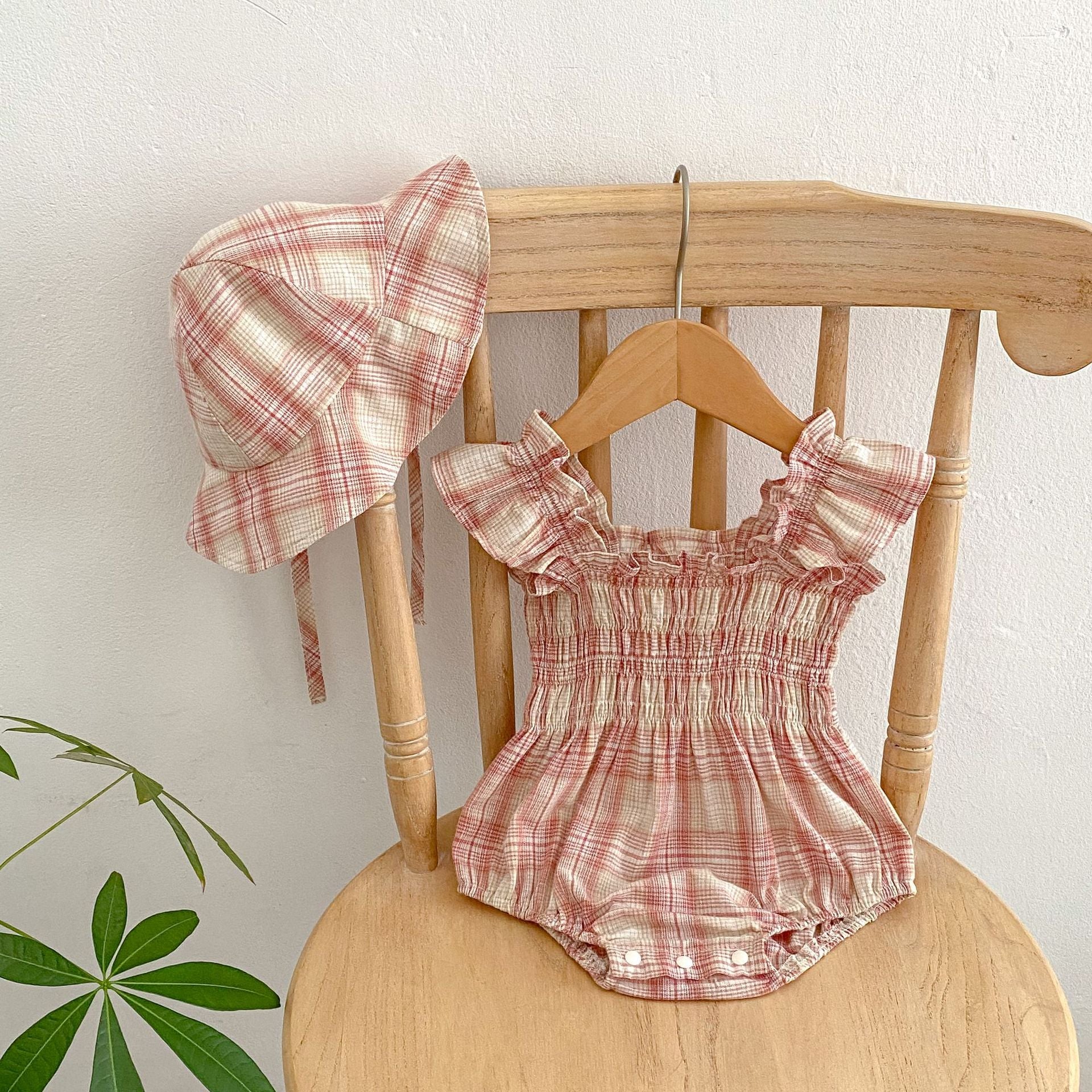 Baby girl plaid pattern onesie with flying sleeves and matching hat in pink and purple colors.