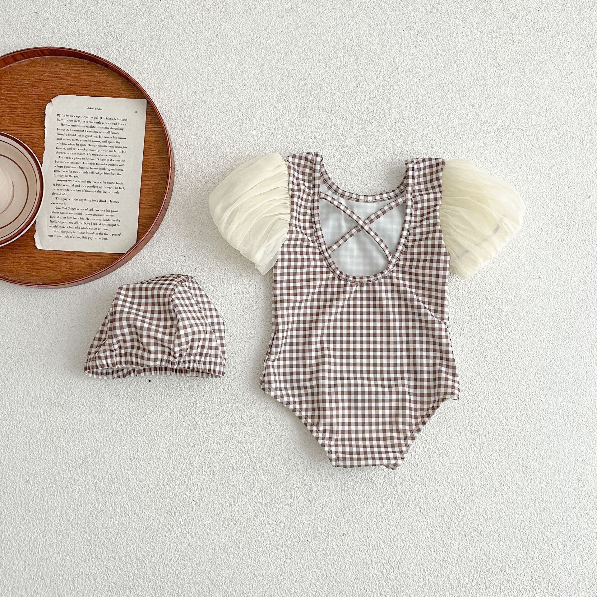 Baby girl swimwear featuring plaid pattern and mesh sleeves, complete with a matching sun hat.