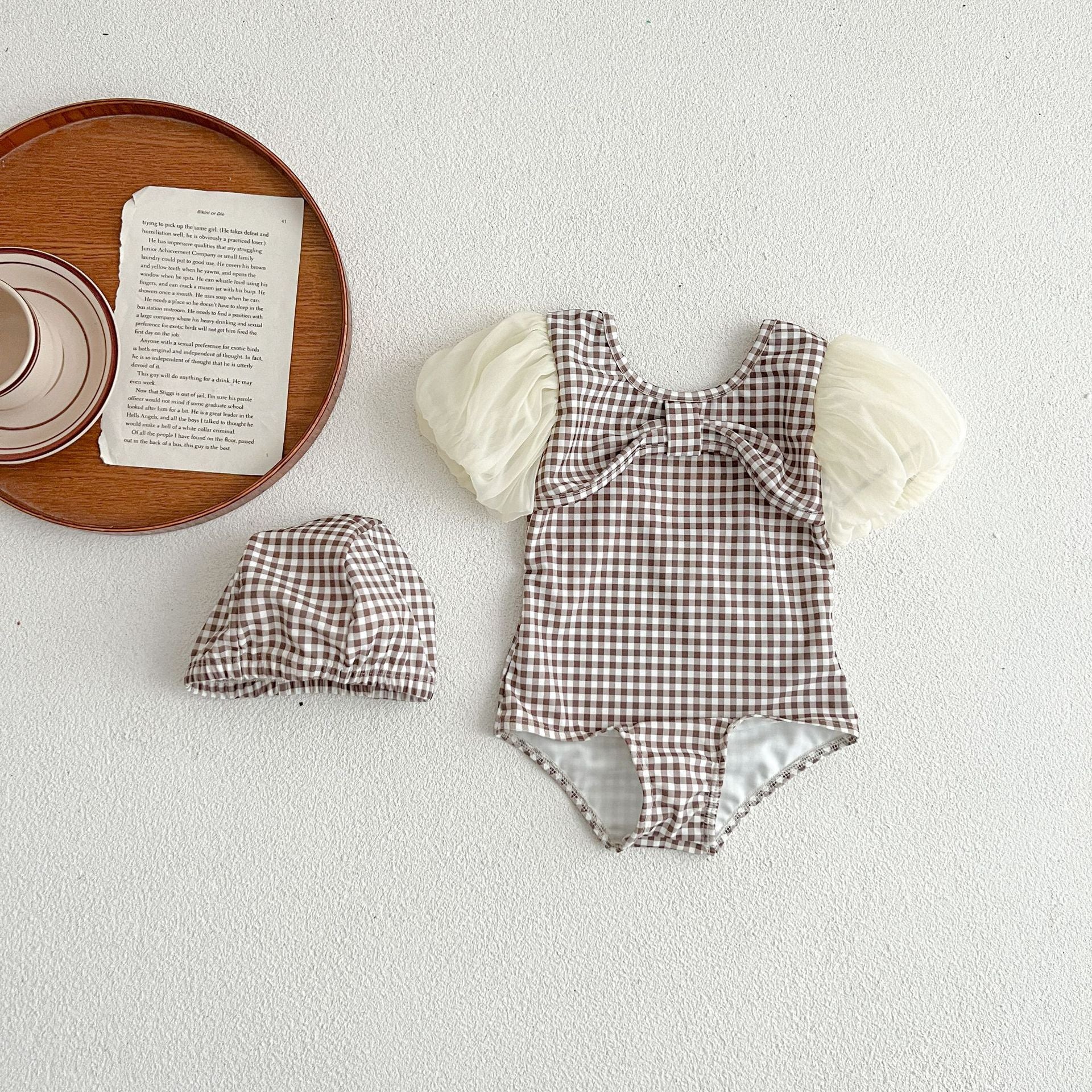 Baby girl swimwear featuring plaid pattern and mesh sleeves, complete with a matching sun hat.