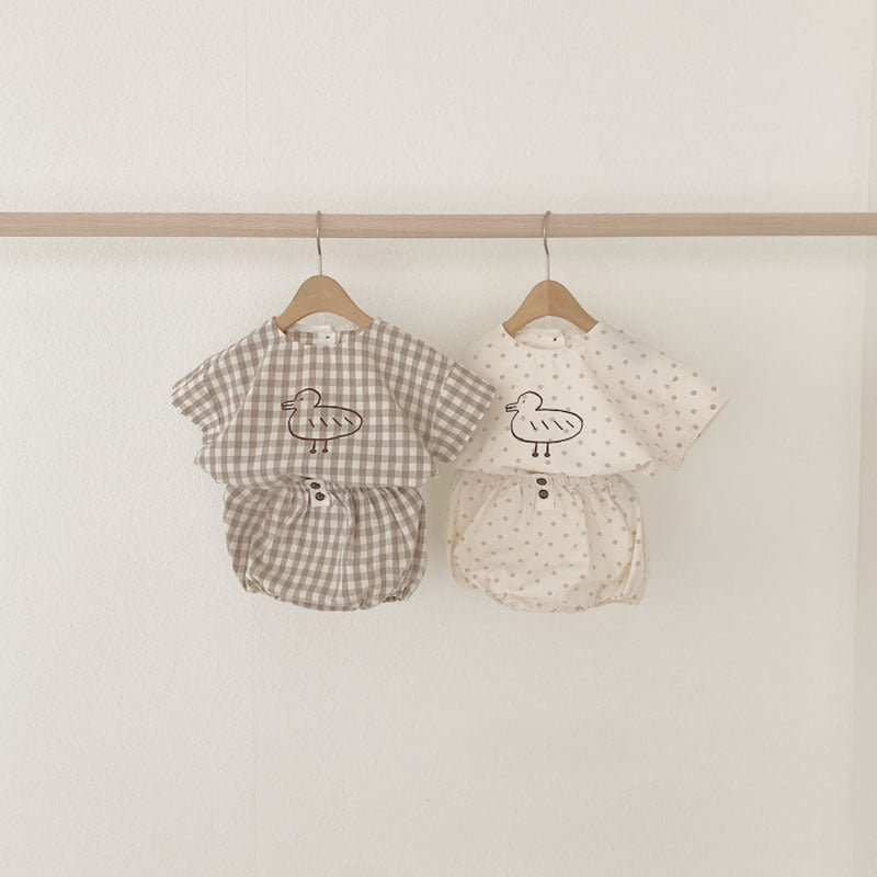 Baby girl short sleeved top featuring plaid and polka dot patterns with a cute duckling print, available in white and brown.