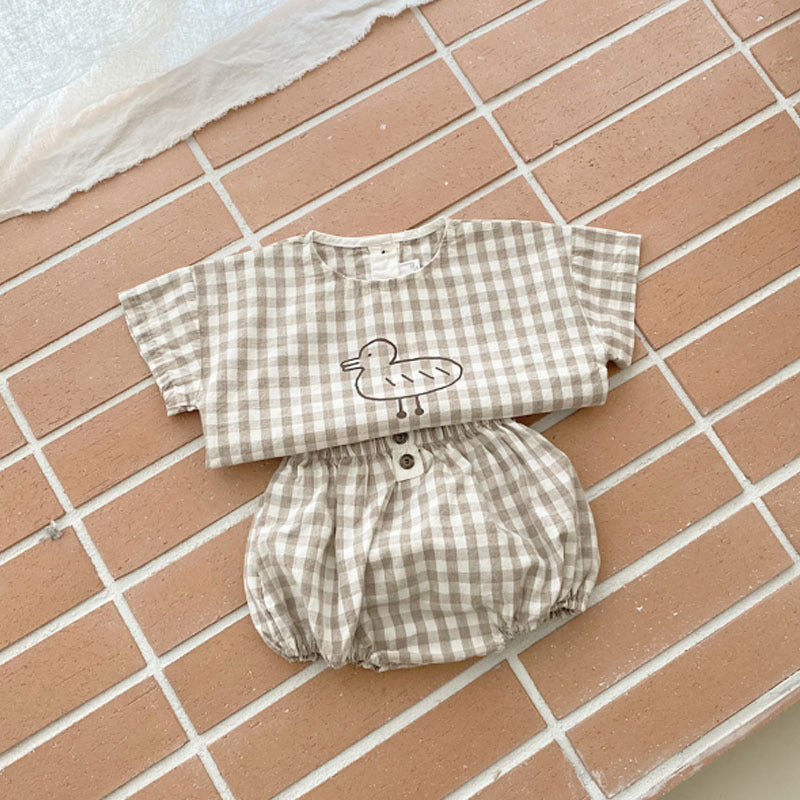 Baby girl short sleeved top featuring plaid and polka dot patterns with a cute duckling print, available in white and brown.