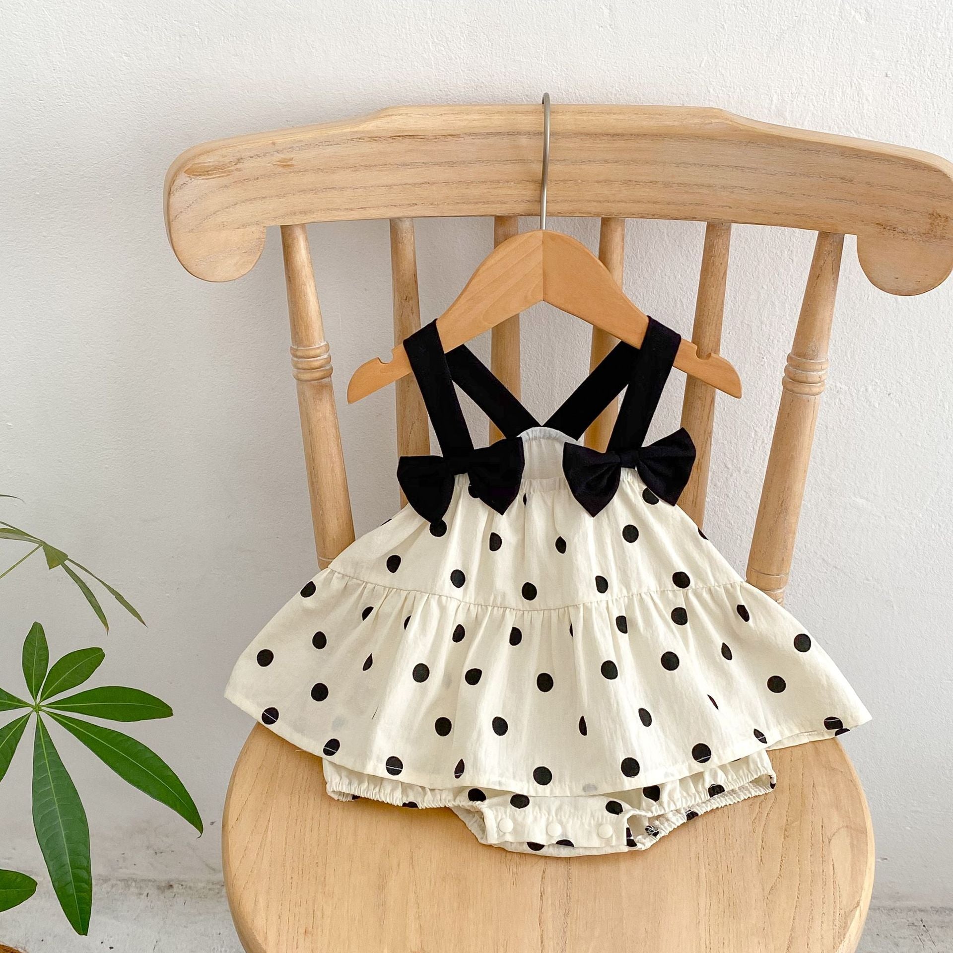 Baby girl sling dress featuring a polka dot pattern and mesh patches in apricot color, perfect for summer wear.