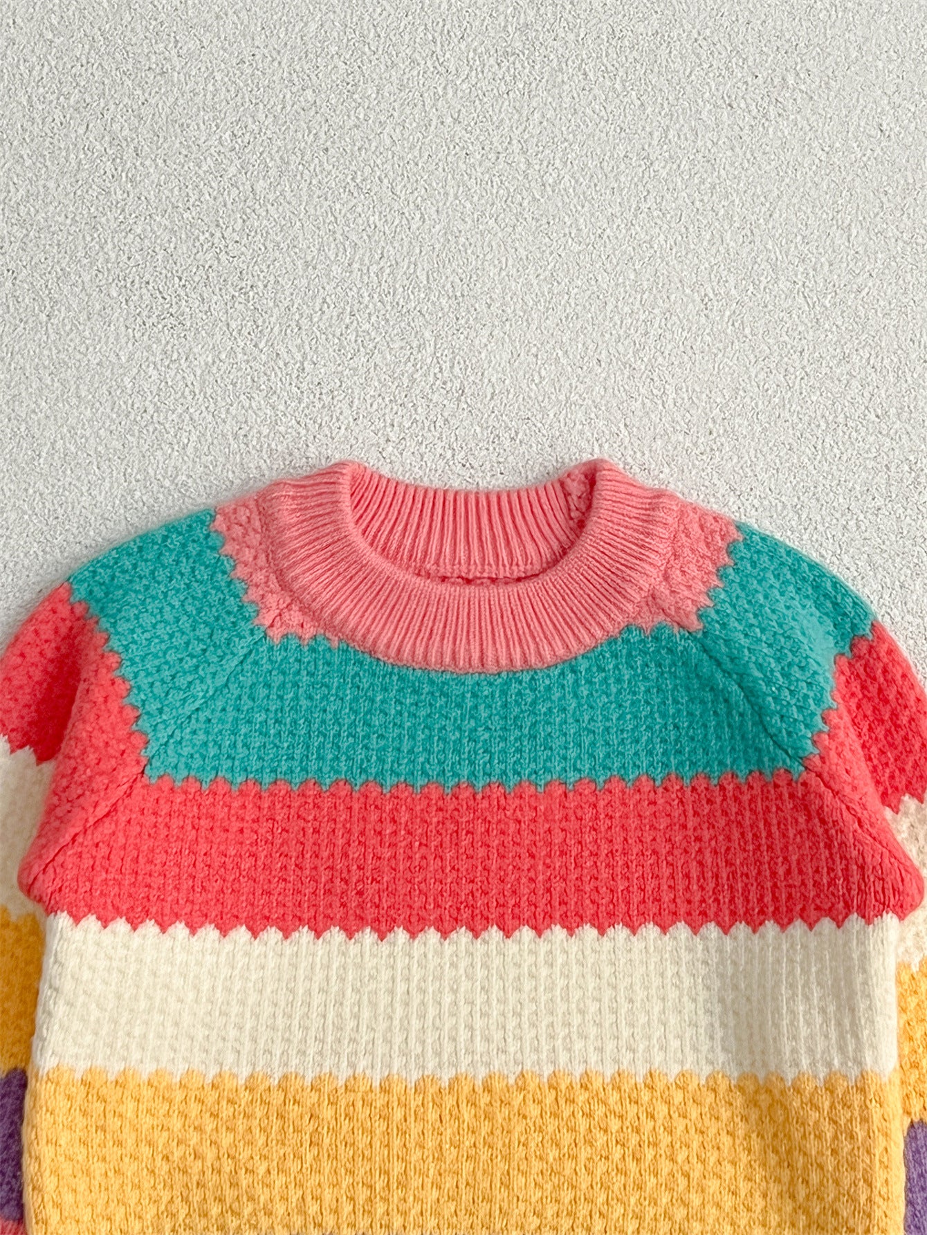 A colorful Baby Girl Rainbow Strips Knitting Pullover Sweater featuring vibrant rainbow stripes, perfect for stylish and cozy wear.