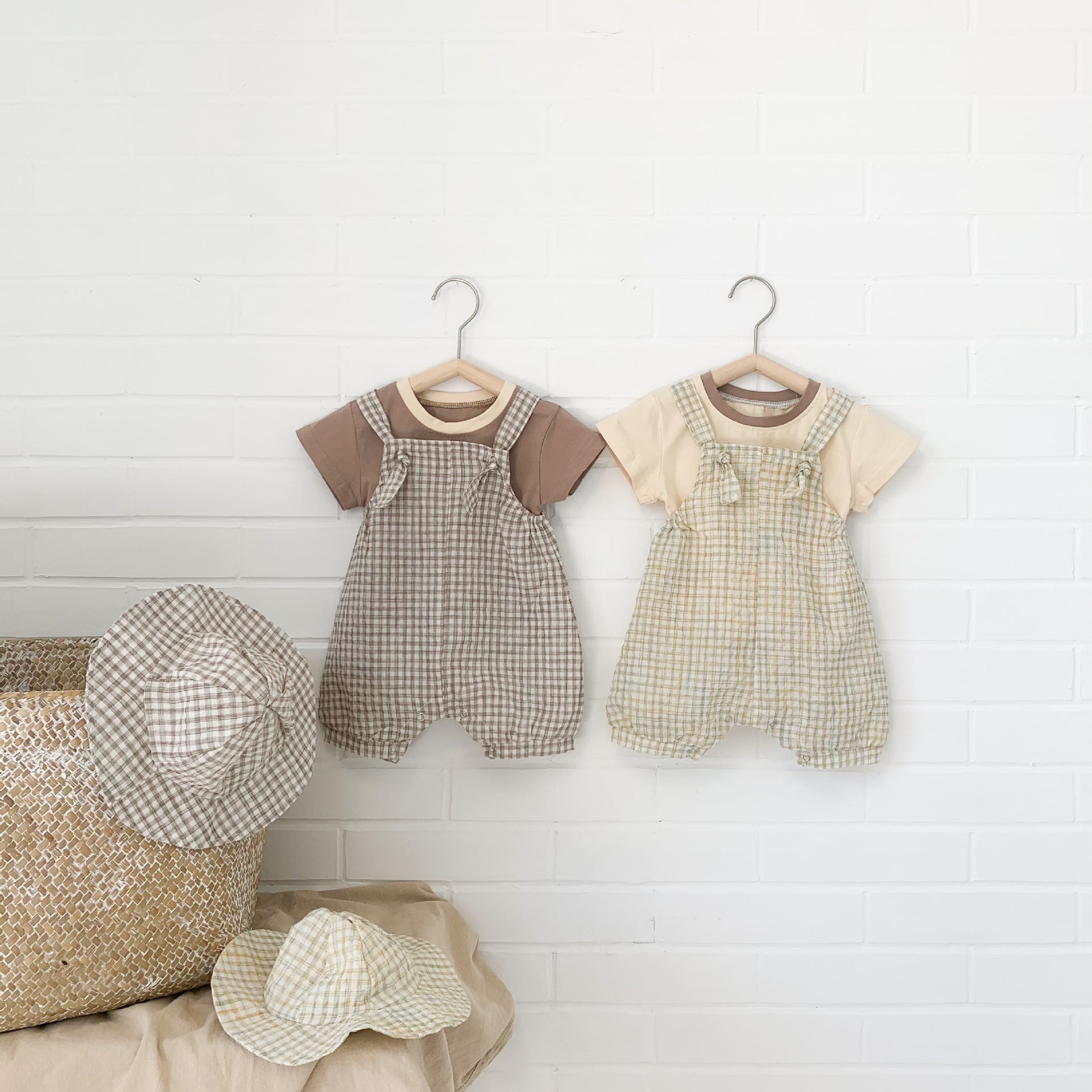 Baby girl wearing a stylish plaid pattern outfit with short sleeves, backpack pants, and a matching hat, perfect for summer.