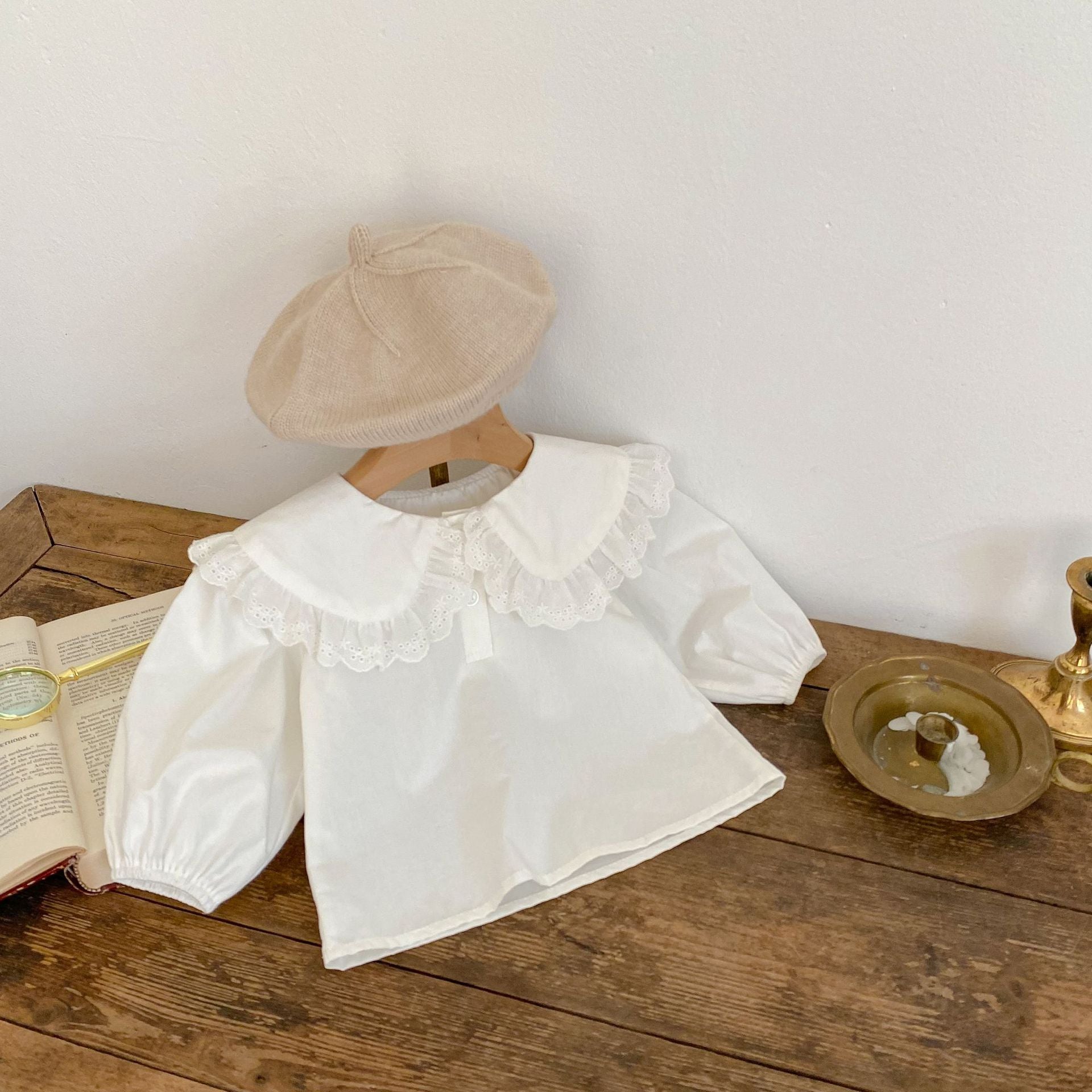 Baby girl solid color long sleeve blouse with doll neck design in white and beige, made from soft cotton material.