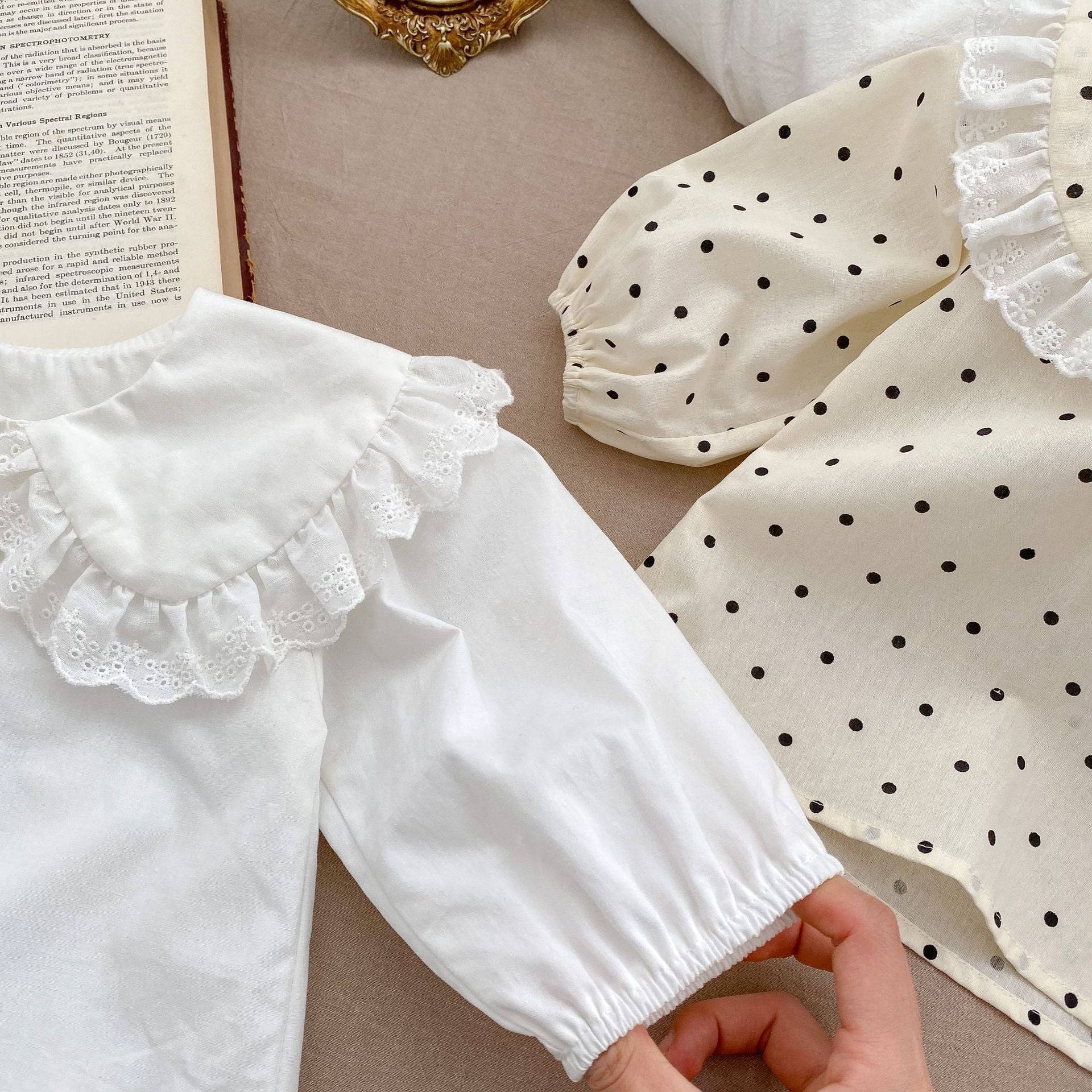 Baby girl solid color long sleeve blouse with doll neck design in white and beige, made from soft cotton material.