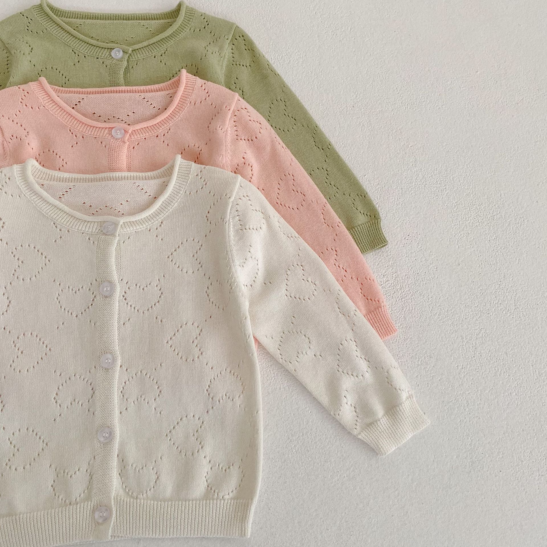 Baby girl cardigan in solid colors with heart hollow carved design, perfect for spring and autumn wear.