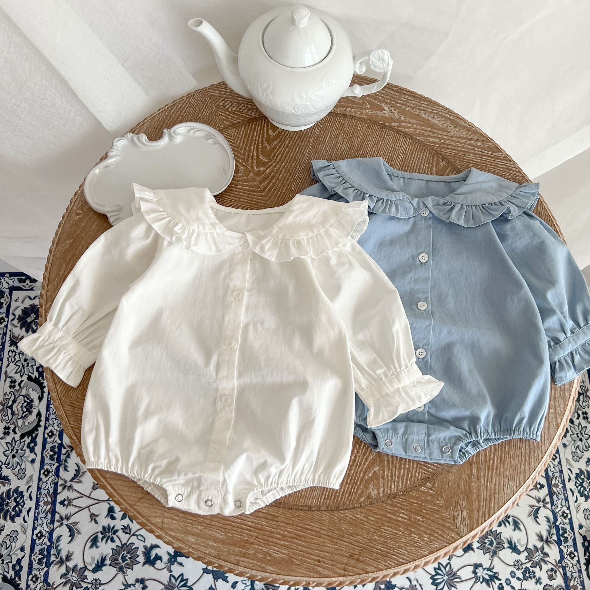 Baby Girl Solid Color Lace Doll Neck Long Sleeve Bodysuit in white and blue, showcasing elegant lace detailing and soft cotton fabric.