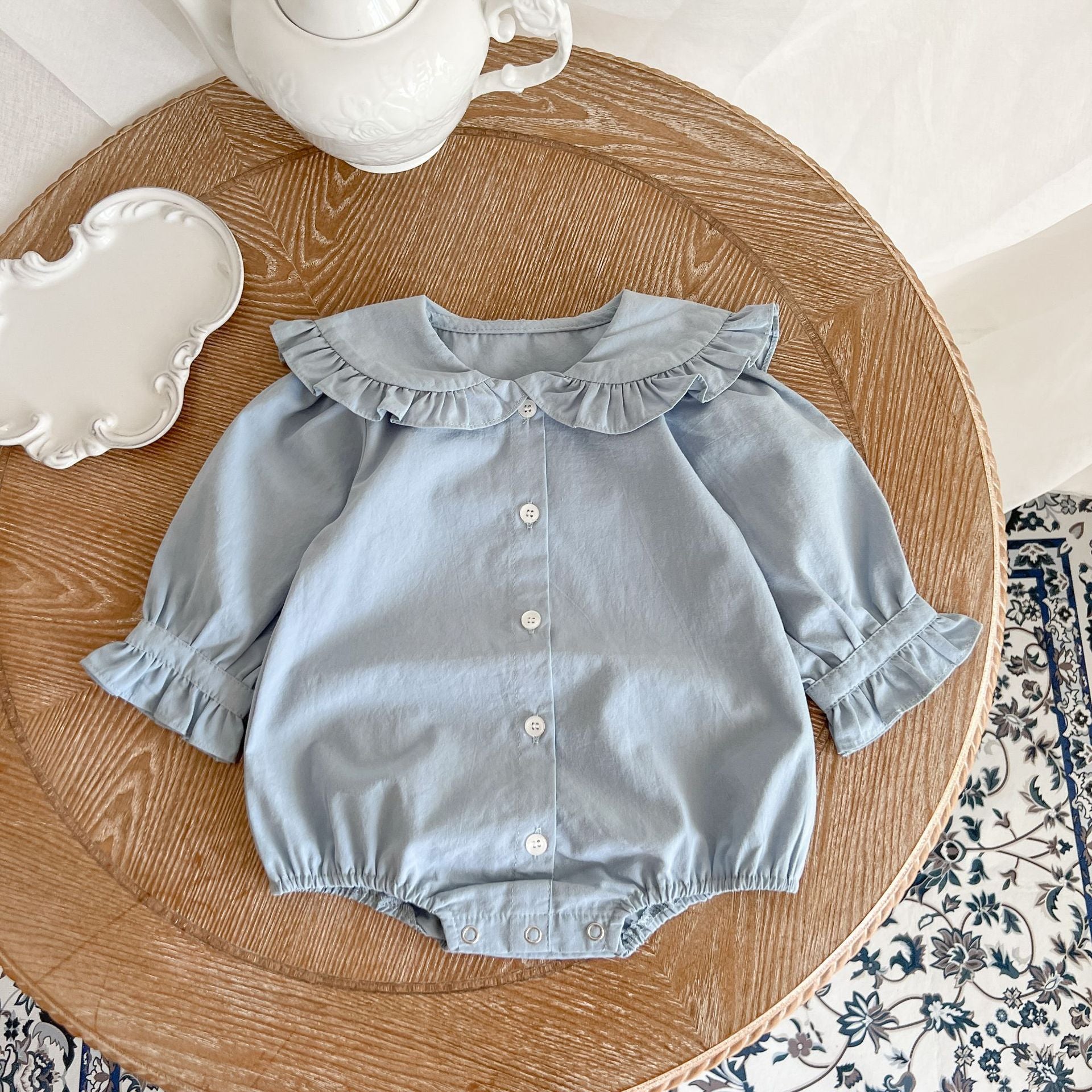 Baby Girl Solid Color Lace Doll Neck Long Sleeve Bodysuit in white and blue, showcasing elegant lace detailing and soft cotton fabric.