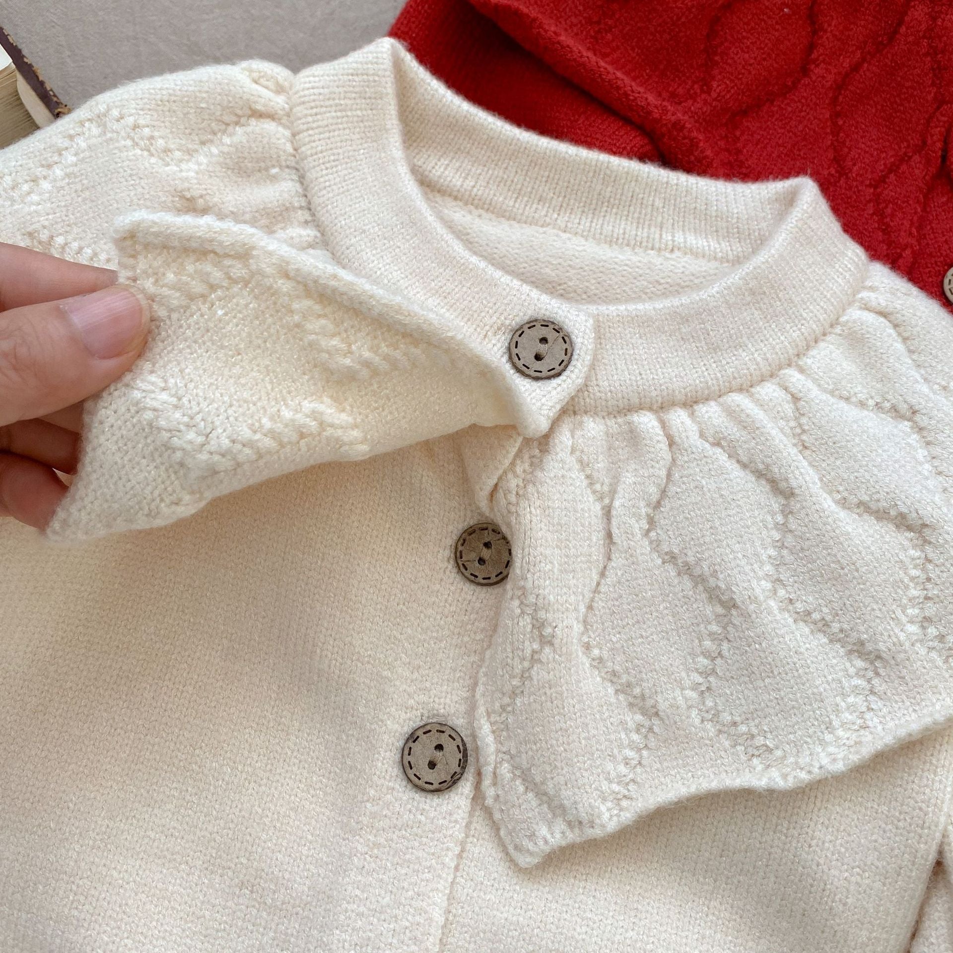 Baby girl solid color knit cardigan with lapel design in white and red, made from soft cotton fabric.