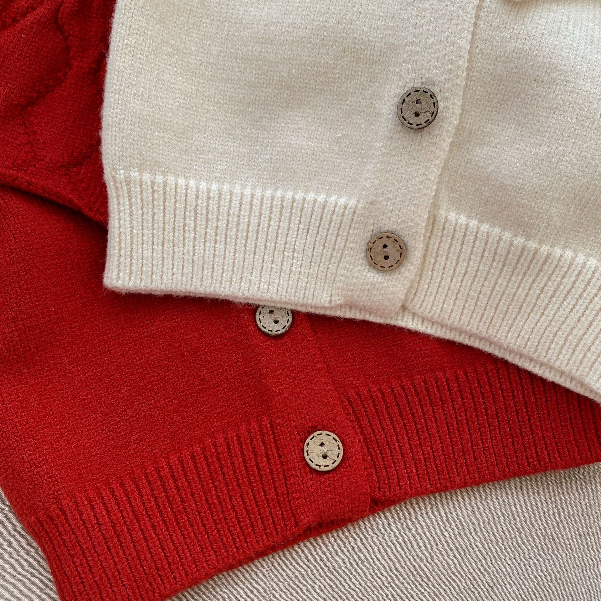 Baby girl solid color knit cardigan with lapel design in white and red, made from soft cotton fabric.