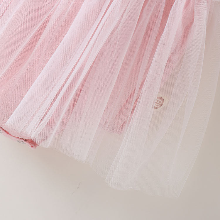 A baby girl wearing a solid color mesh patchwork sleeveless dress in pink, complemented by a delicate headband.