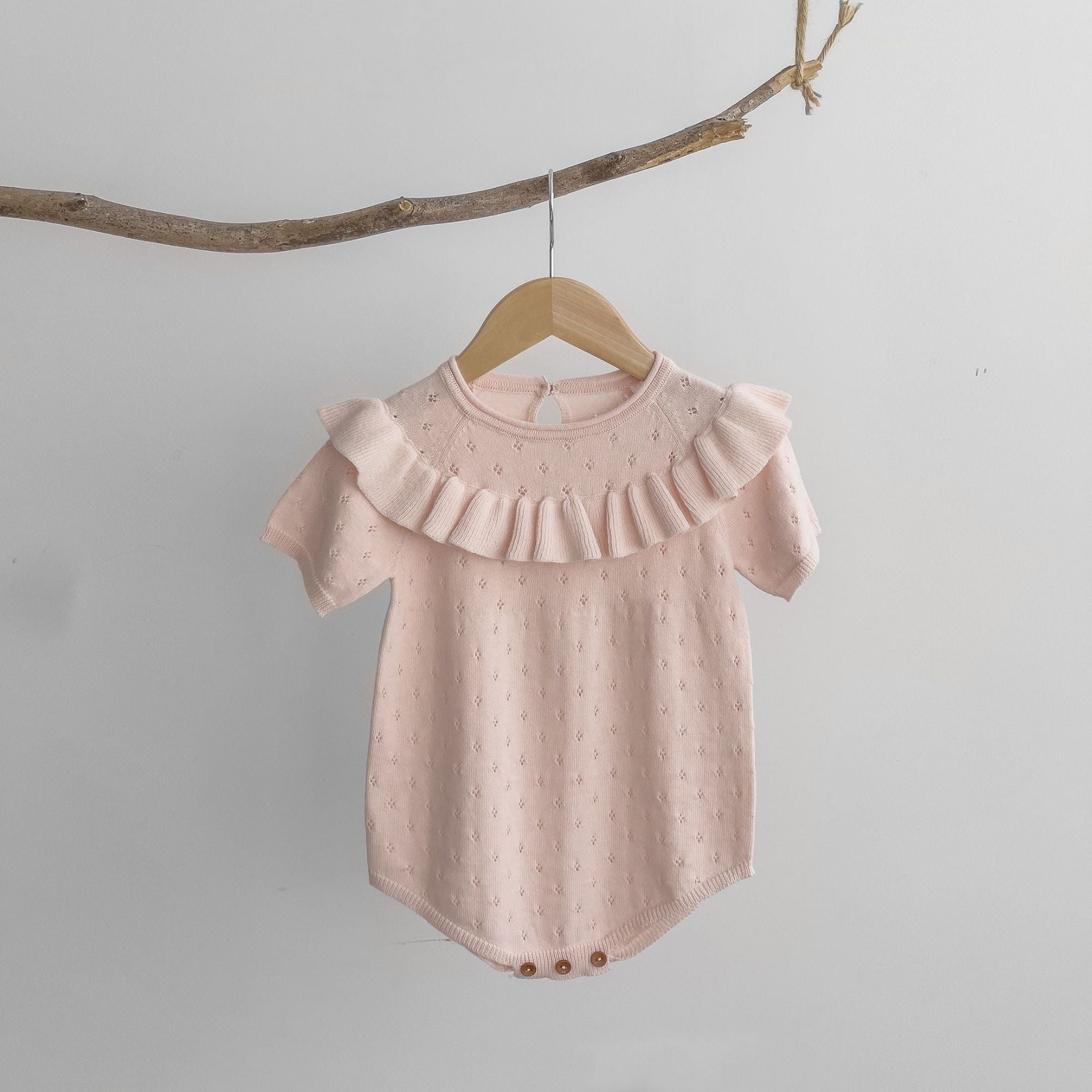 Baby girl solid color knitted onesies with ruffle design in white and pink, made from breathable cotton.