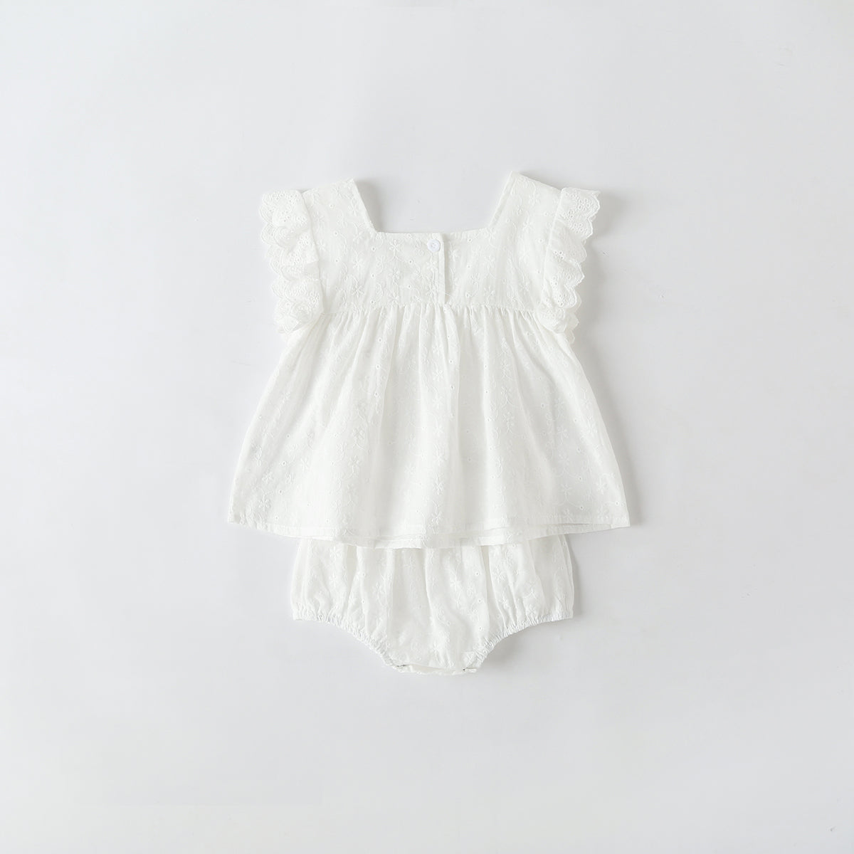 Baby girl wearing a solid color ruffle design square neck top in white, showcasing a stylish and comfortable summer outfit.