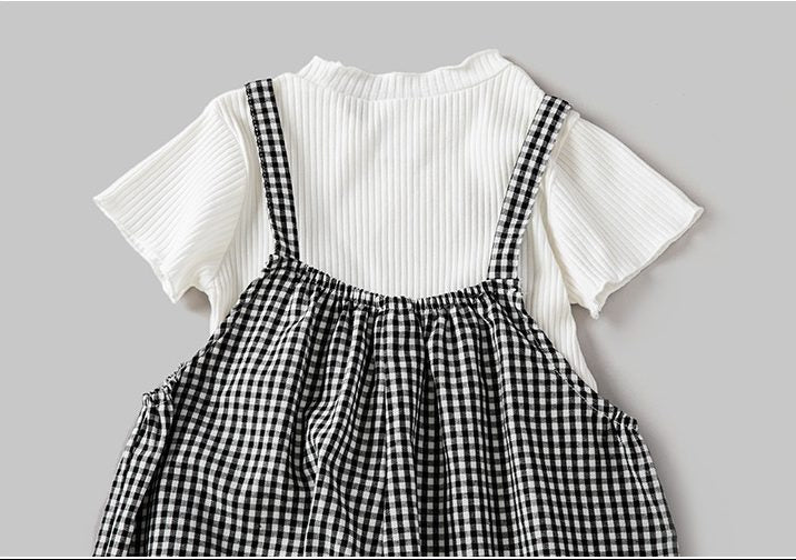 A stylish 2-piece set for baby girls featuring a solid color top and plaid pattern overalls in black, perfect for summer wear.